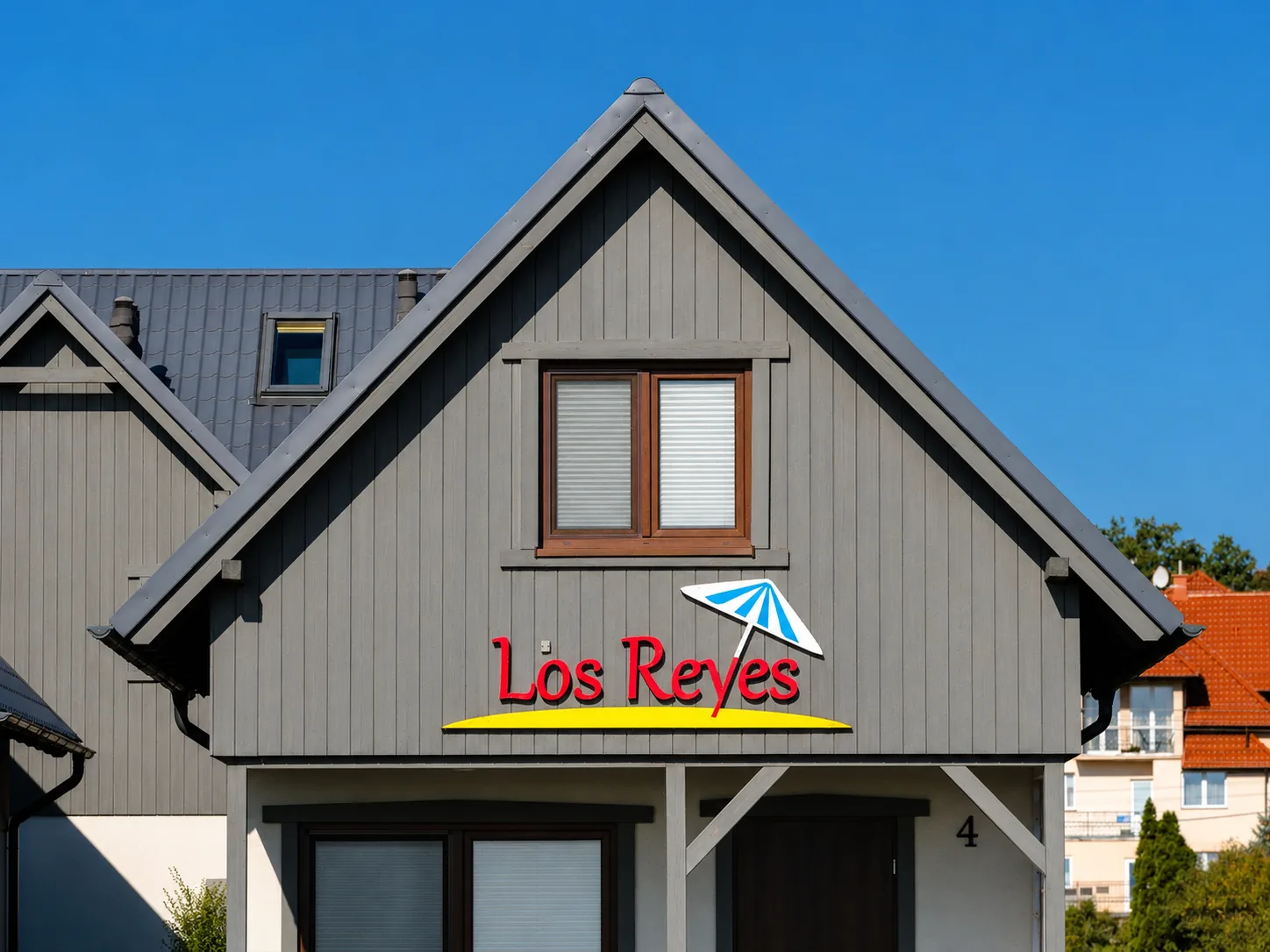 Logo Los Reyes na elewacji domku